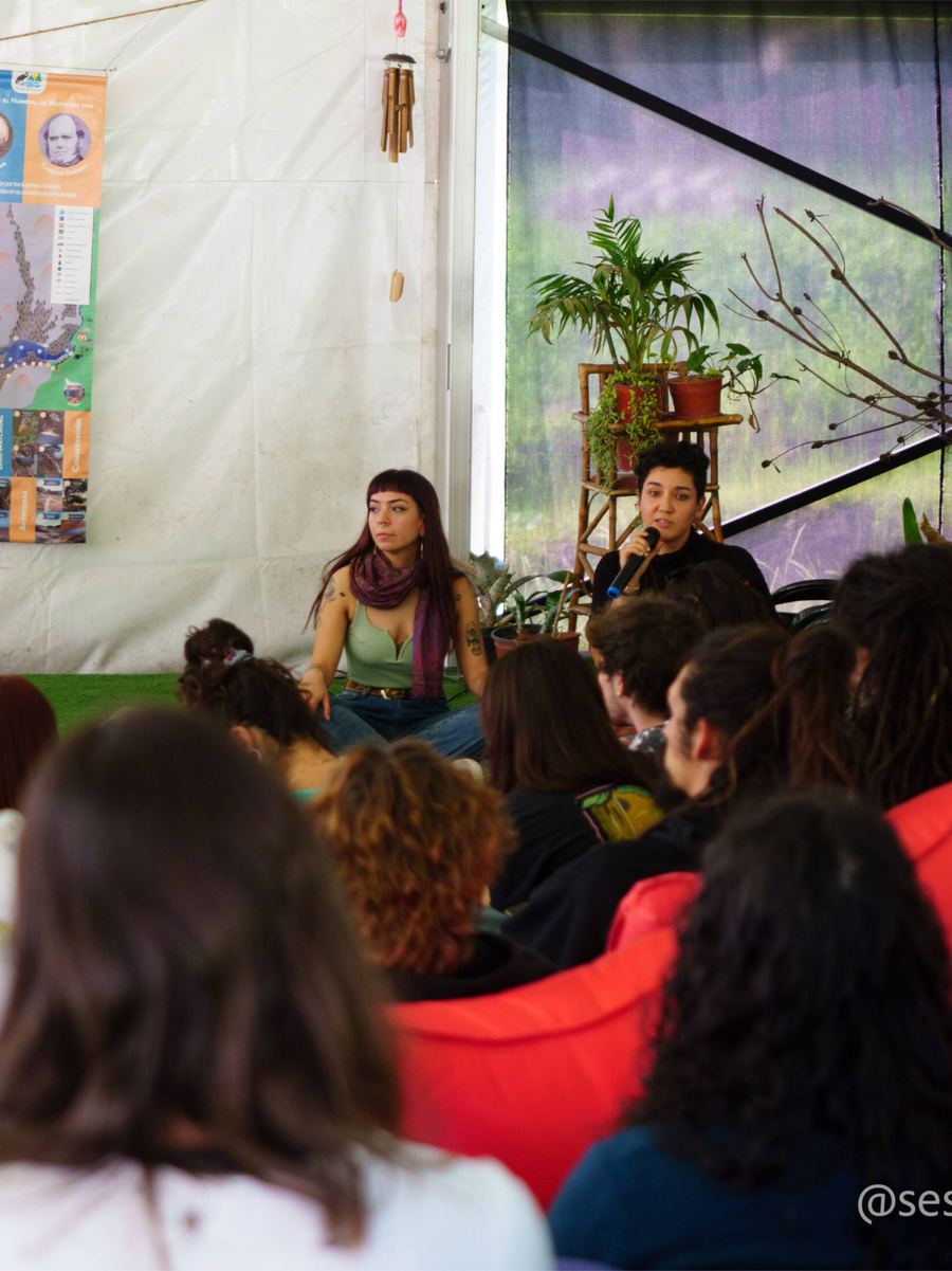 Charla del festival con el público sentado en pufs