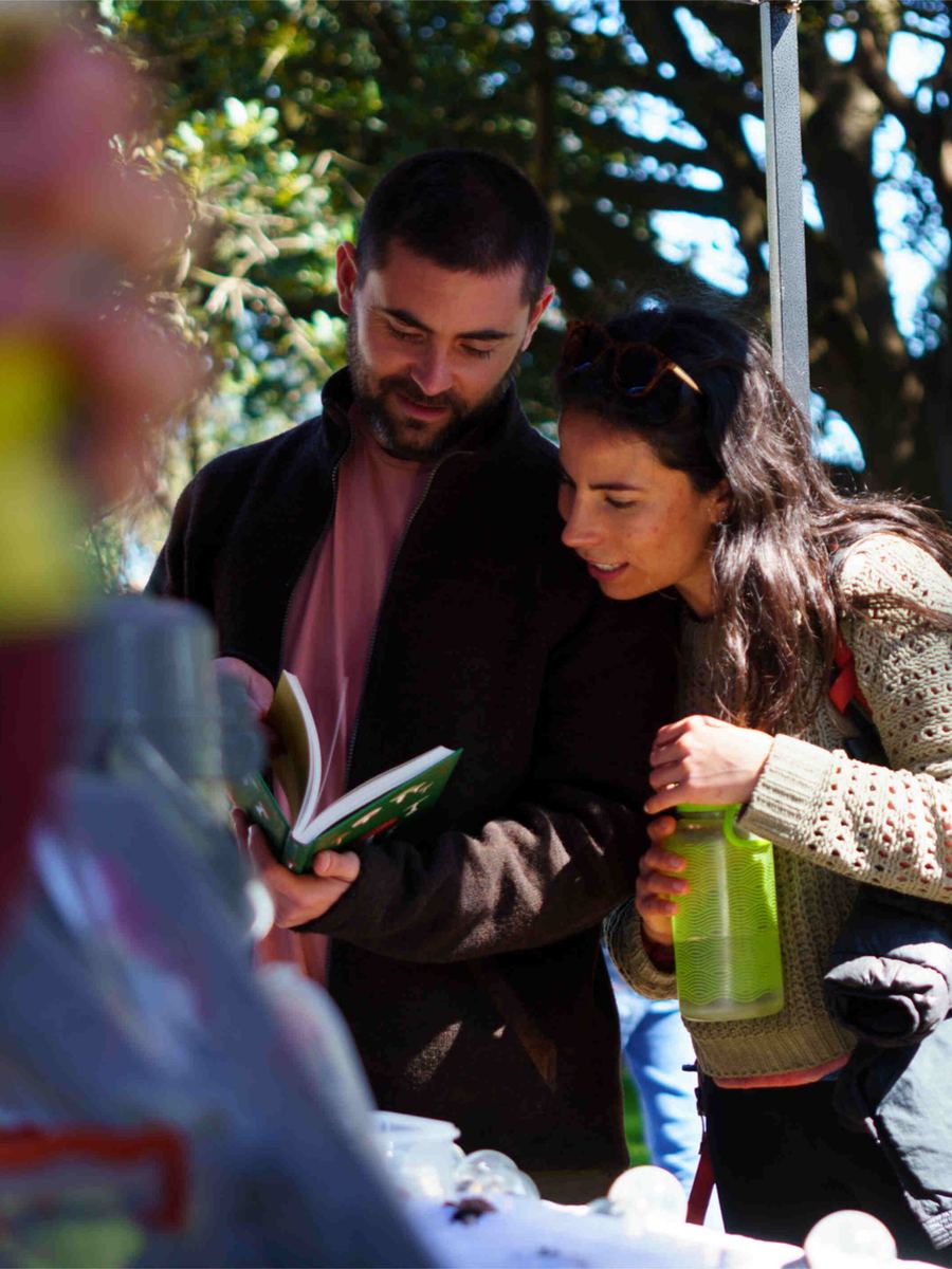 Dos personas revisan un libro en la feria del festival